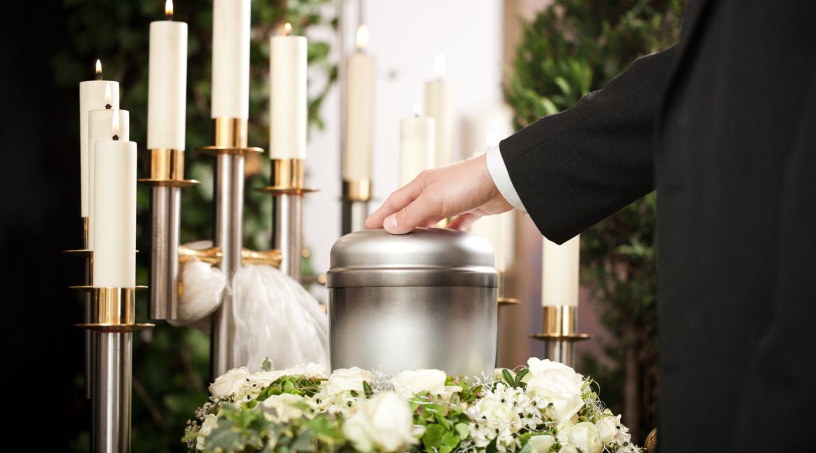 Urna di metallo a un funerale con le candele