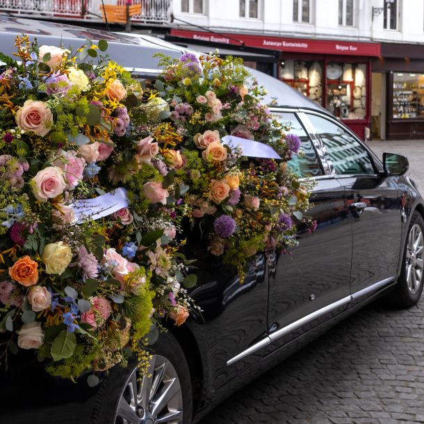 Carro funebre con corona floreale. Servizi funebri rituali in una città europea.
