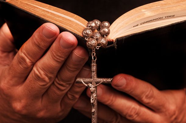 Croce e Bibbia nelle mani primo piano